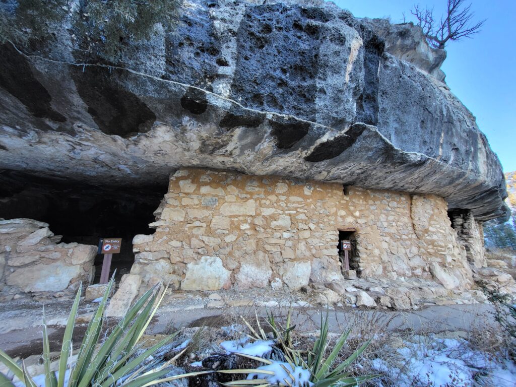 Cliff dwellings built with stone and mud into the limestone ledge of a canyon